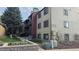 Exterior side view of condo building, showcasing unit number, landscaping, and utilities at 10890 W Evans Ave # 2E, Lakewood, CO 80227