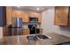 Well-equipped kitchen with stainless steel appliances, wood cabinets, and a functional double-basin sink at 10890 W Evans Ave # 2E, Lakewood, CO 80227