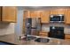 Updated kitchen features granite countertops, stainless steel appliances, and wood cabinets at 10890 W Evans Ave # 2E, Lakewood, CO 80227