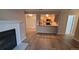 Open-concept living space showcasing the fireplace and adjacent kitchen area with bar seating at 10890 W Evans Ave # 2E, Lakewood, CO 80227