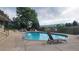 Community pool surrounded by lounge chairs, trees and mountain views at 10890 W Evans Ave # 2E, Lakewood, CO 80227