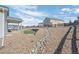 Landscaped backyard featuring a covered patio, a small turf area, and decorative rock elements at 42338 Forest Oaks Dr, Elizabeth, CO 80107