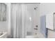 Bright bathroom with white-tiled shower and tub featuring neutral-colored shower curtain and coordinating blue towels at 4680 Copeland Loop # 204, Highlands Ranch, CO 80126