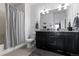 Bathroom with double sink vanity, granite countertop, and shower with gray curtain at 4680 Copeland Loop # 204, Highlands Ranch, CO 80126