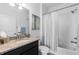 Bright bathroom with granite vanity and shower featuring white tiled surround and rainfall shower head at 4680 Copeland Loop # 204, Highlands Ranch, CO 80126