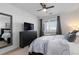 Bright bedroom featuring a comfortable bed, TV, dresser, and a window at 4680 Copeland Loop # 204, Highlands Ranch, CO 80126