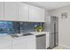 Elegant kitchen with stainless steel appliances, blue backsplash, and white cabinets at 2405 W 39Th Ave, Denver, CO 80211