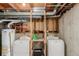 Unfinished basement laundry area features a water heater, two washing machines, and wooden shelving at 11560 Otis St, Westminster, CO 80020