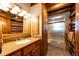 Classic log cabin bathroom featuring a wood vanity, mirrored cabinet, and shower-tub combination, radiating rustic charm at 2965 Wagner St, Strasburg, CO 80136