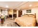 Cozy basement bedroom featuring wood-look flooring, warm lighting, and access to the living room creating a relaxing space at 2965 Wagner St, Strasburg, CO 80136