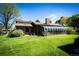 Log home featuring a glass-enclosed sunroom and well-maintained lawn, merging indoor-outdoor living at 2965 Wagner St, Strasburg, CO 80136