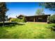 Charming log home with lush green lawn and mature landscaping creates a welcoming exterior at 2965 Wagner St, Strasburg, CO 80136
