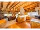 Open floor plan, showing kitchen and living room area with log walls at 2965 Wagner St, Strasburg, CO 80136