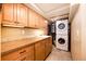 Well-equipped laundry room with ample storage cabinets, countertop space, and stacked washer/dryer at 2965 Wagner St, Strasburg, CO 80136