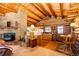 View of the fireplace, kitchen and wooden dining set in this log home at 2965 Wagner St, Strasburg, CO 80136