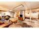 Inviting basement living room with leather seating, wood-look flooring, and seamless flow to the kitchenette and bedroom at 2965 Wagner St, Strasburg, CO 80136