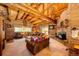 Spacious living room featuring a stone fireplace and log beam ceiling at 2965 Wagner St, Strasburg, CO 80136