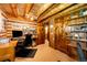 Rustic home office with log walls, wooden doors, and convenient built-in shelving with a view of an adjoining bathroom at 2965 Wagner St, Strasburg, CO 80136