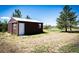Exterior view of brown storage shed perfect for storing equipment and tools on the property at 2965 Wagner St, Strasburg, CO 80136
