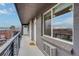 Apartment balcony with railing overlooks neighborhood and a large window provides natural light at 120 S Pennsylvania St # 302, Denver, CO 80209
