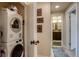 Hallway features a stacked washer and dryer leading to a bathroom with double vanity at 120 S Pennsylvania St # 302, Denver, CO 80209