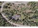 Aerial view of a home nestled among trees featuring a long driveway and solar panels on the roof at 8722 S Ault Ln, Morrison, CO 80465