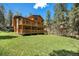 Expansive backyard with a spacious wooden deck perfect for entertaining amidst lush greenery at 8722 S Ault Ln, Morrison, CO 80465