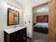 Bathroom vanity with framed mirror and light fixture, door opening to bedroom at 8722 S Ault Ln, Morrison, CO 80465