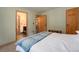 Bright bedroom with neutral walls, natural wood trim, and open bathroom entrance at 8722 S Ault Ln, Morrison, CO 80465