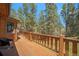 Inviting wooden deck overlooking a lush green landscape with tall trees, perfect for outdoor relaxation at 8722 S Ault Ln, Morrison, CO 80465
