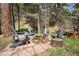 Cozy outdoor fire pit area with Adirondack chairs nestled among the trees for relaxation and gatherings at 8722 S Ault Ln, Morrison, CO 80465