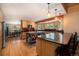 Open kitchen boasts wood cabinetry, granite counters, an island, and eat-in breakfast bar at 8722 S Ault Ln, Morrison, CO 80465