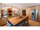 Open kitchen and living area with wood cabinets, granite countertops, and large island at 8722 S Ault Ln, Morrison, CO 80465