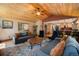 Comfortable living area with wood ceilings, hardwood floors, and seamless flow to the kitchen at 8722 S Ault Ln, Morrison, CO 80465
