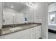 Bathroom featuring double sinks with gray countertops and white cabinets with walk-in shower at 12738 Boggs St, Parker, CO 80134