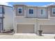 Close-up of modern townhome exteriors, highlighting garage doors and neutral siding at 12738 Boggs St, Parker, CO 80134