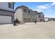 Modern townhomes in gray tones with a shared parking area and individual garages at 12738 Boggs St, Parker, CO 80134