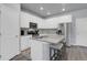 Modern kitchen features white cabinetry, stainless steel appliances, and an island with seating at 12738 Boggs St, Parker, CO 80134