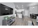 Open-concept living space with sleek floors, modern kitchen, and comfortable dining area for seamless entertaining at 12738 Boggs St, Parker, CO 80134