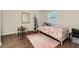 Cozy bedroom features a white-painted wood bed and hardwood floors with a pink area rug at 1600 S Quebec Way # 8, Denver, CO 80231