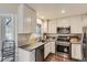 Well-lit kitchen featuring stainless steel appliances and bright white cabinetry at 1600 S Quebec Way # 8, Denver, CO 80231