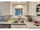 Clean kitchen showcasing white cabinets, stainless steel sink, and a modern subway tile backsplash at 1600 S Quebec Way # 8, Denver, CO 80231