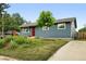 Charming single-story home with blue siding, a red door, and a well-maintained front yard and walkway at 2011 S Vallejo St, Denver, CO 80223