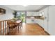 Well-lit kitchen and dining area featuring white cabinets, hardwood floors, and a sliding glass door to the backyard at 2011 S Vallejo St, Denver, CO 80223