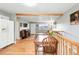 Open-concept living room featuring hardwood floors, exposed beam, and a staircase to the dining area at 2011 S Vallejo St, Denver, CO 80223