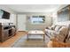 Cozy living room featuring hardwood floors, a comfortable sofa, and a bright window at 2011 S Vallejo St, Denver, CO 80223