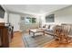 Comfortable living room with hardwood floors, a plush sofa, rocking chair, and a large area rug at 2011 S Vallejo St, Denver, CO 80223