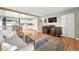 Open concept living room flowing into the kitchen, featuring hardwood floors and cozy furniture at 2011 S Vallejo St, Denver, CO 80223