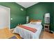 Bedroom with green walls, hardwood floors, large bed, and stylish décor at 1820 Mary Ln # 1, Boulder, CO 80304