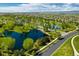 Aerial view of the community featuring multiple ponds, green spaces, sidewalks, and neighborhood homes at 15720 Columbus Mountain Dr, Broomfield, CO 80023